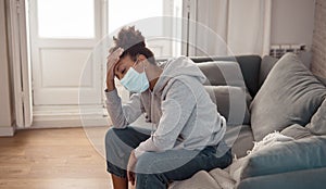 Young black woman wearing protective mask against COVID virus suffering from depression
