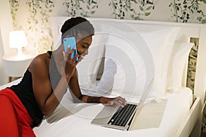 Young black woman working on her bed in her bedroom