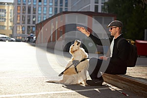 Young blind man training guide dog, giving obedience commands