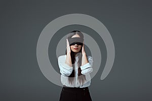 young blindfolded woman closing ears