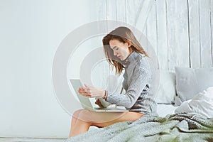 Young blogger or business woman working at home with social media, drinking coffee in early morning in bed