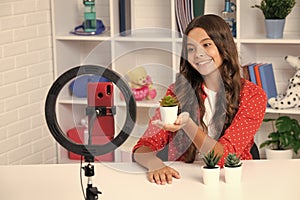 Young blogger girl recording video for blog. Teen girl speaking in front of camera for vlog. Teenager working as blogger