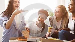 Young blogger taking photo of pizza, having party with friends