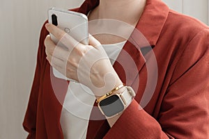 Young blogger wear trendy jacket and smart watch holding white smartphone in hand