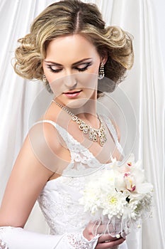 A young blond bride posing in a white dress