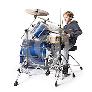 Young blond caucasian boy at drumset in studio