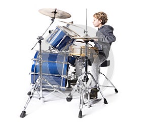 Young blond caucasian boy at drumset in studio