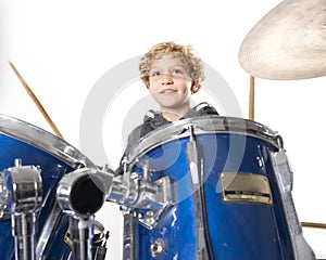 Young blond caucasian boy at drumset in studio