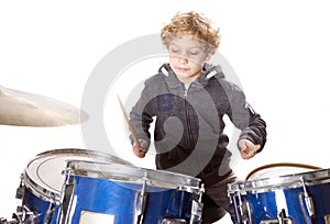 Young blond caucasian boy at drumset in studio