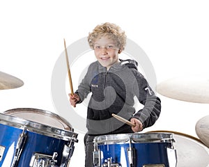 Young blond caucasian boy at drumset in studio