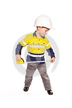 Young blond caucasian boy measuring something role playing as a construction worker in a yellow and blue hi-viz shirt