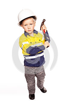 Young blond caucasian boy role playing as a construction worker in a yellow and blue hi-viz shirt, boots, white hard hat