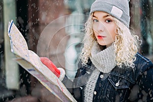 Young blond curly girl with map of London, winter