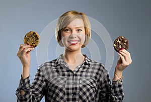 Young blond cute and friendly caucasian woman in casual clothes holding two big chocolate cookies