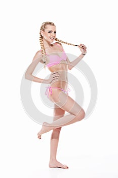 young blond girl fashion posing in pink bikini.