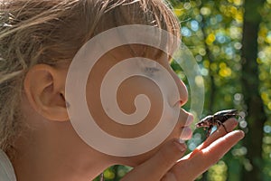 Young blond girl kissing a bug she found