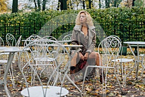 Young blond girl sitting at table in public park