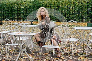 Young blond girl sitting at table in public park