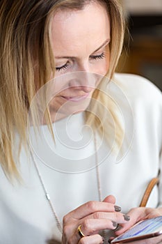 Young blond hair business woman writing a text message using mes