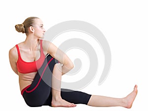 Young blond hair woman in yoga pose bharadvajasana or twisting sage pose