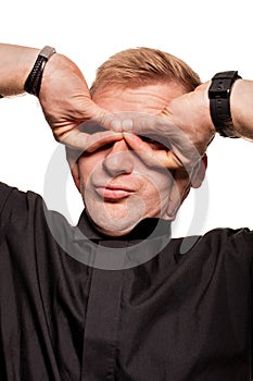 Young blond man in a black shirt, watches and bracelet is making faces, isolated on a white background