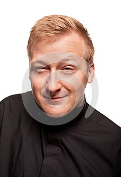 Young blond man in a black shirt, watches and bracelet is making faces, isolated on a white background