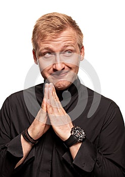 Young blond man in a black shirt, watches and bracelet is making faces, isolated on a white background