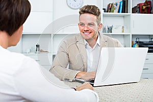 Young blond man and businesswoman communicate