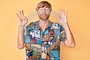 Young blond man wearing summer shirt relaxed and smiling with eyes closed doing meditation gesture with fingers