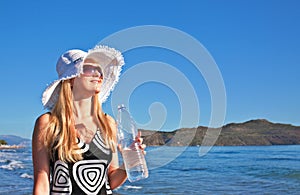 Young blond woman with bottle of water