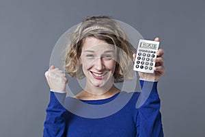 Young blond woman clenching fist and calculator