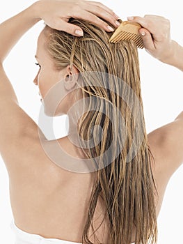 Young Blond Woman Combing Wet Hair photo