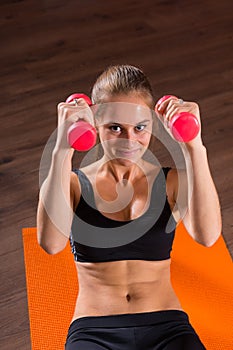 Young Blond Woman Doing Crunches with Hand Weights