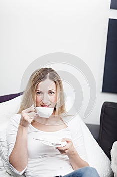 Young blond woman enjoying a cup of coffee