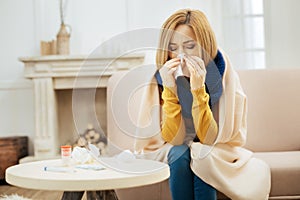 Young blond woman having fever and running nose