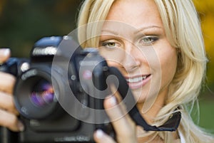 Young blond woman holding camera