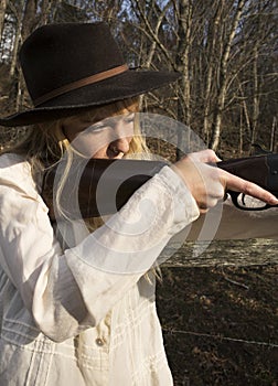 Young blond woman holding up a gun