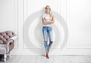 Young blond woman leaning on a decorative wall