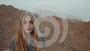 Young blond woman in long dress walks on top of mountain. Mountain landscape with sunset, slow motion, full hd