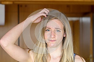 Young blond woman scratching her head