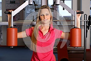 A young blond woman training in a fitness gym