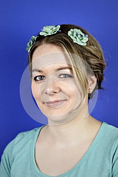 Young blond woman with updo hair and cyan flowers