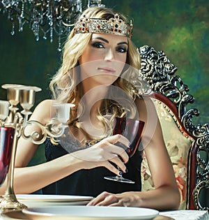 young blond woman wearing crown in fairy luxury interior with empty antique frames total wealth concept