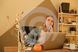 Young blond woman working laptop. Business woman busy working on laptop computer at office.