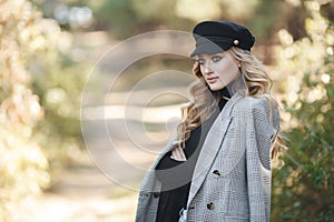 Young blonde beautiful woman spends time alone on a sunny day in a city park