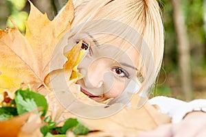 Young blonde behind the leaves