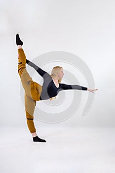 Young blonde blue-eyed dancer woman on white background