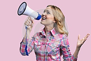 Young blonde blue-eyed woman speaking in megaphone.