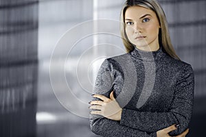 Young blonde business woman or female student standing straight and posing at camera. Lifestyle concept