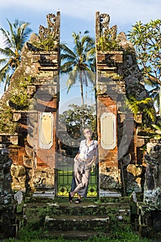 Young blonde caucasian woman traveling and exploring traditional hidu tamples around Ubud on Bali.